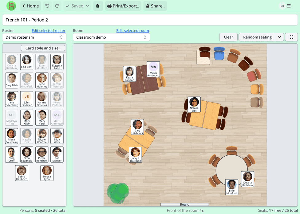 A screenshot of a school seating chart being generated in Seating Chart Maker. The classroom has 25 seats in different kind of table groups. The classroom is a simple rectangle with a whiteboard at the front, with a wooden floor and a decorative plant. Person cards show person names and portraits and visually indicate where the person is seated.